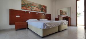 1 dormitorio con 1 cama grande en una habitación en Elga Hotel, en Kardamaina