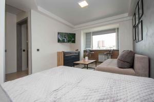 a bedroom with a large bed and a couch at MYFREEDOM Апартаменти метро Оболонь in Kyiv