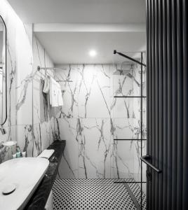 a black and white bathroom with a sink and a shower at Rila Hotel Sofia in Sofia