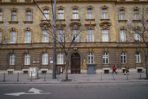 een groot bakstenen gebouw waar mensen voor lopen bij Cityscape Apartments Kerepesi in Boedapest