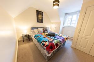 a bedroom with a bed with a colorful blanket at Manhattan Hideaway Warrington in Burtonwood