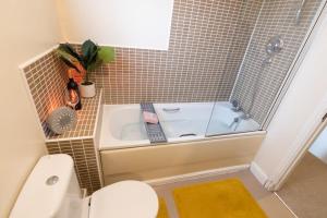 een badkamer met een wastafel, een bad en een toilet bij Manhattan Hideaway Warrington in Burtonwood
