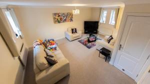 a living room with a couch and a television at Manhattan Hideaway Warrington in Burtonwood