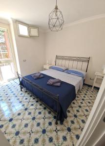 Schlafzimmer mit einem Bett mit blauer Decke in der Unterkunft B&B La Marinella in Palinuro