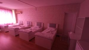 Habitación de color rosa con 4 camas en ESEN OTEL, en Antalya