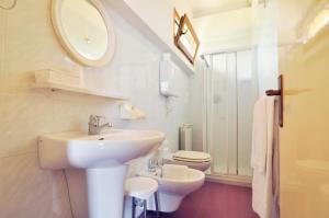 La salle de bains blanche est pourvue d'un lavabo et de toilettes. dans l'établissement Casa Antonelli, à Malcesine