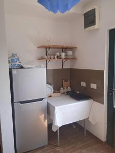 een kleine keuken met een tafel en een koelkast bij Villa Elena Zagora in Neodi