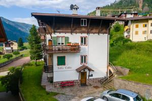 ein Haus in den Bergen mit einem Auto davor geparkt in der Unterkunft Villa Catia in Moena