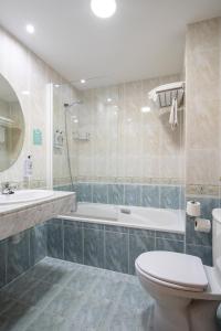 ein Badezimmer mit einer Badewanne, einem WC und einem Waschbecken in der Unterkunft Hostal Alda Río Duero in Soria