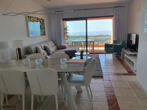 uma sala de estar com uma mesa e cadeiras e um sofá em Royal Apartment 2 /freeWiFi,sharedpool,freeparking em Málaga