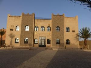 un gran edificio de ladrillo con muchas ventanas en Riad La Luna en Merzouga