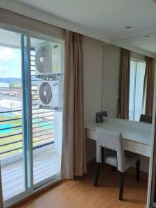 Cette chambre dispose d'un bureau et d'une grande fenêtre. dans l'établissement 2 Bedroom Apartment only 10 min from Patong beach, à Kathu