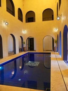 a swimming pool in a building with arches at Riad La Luna in Merzouga