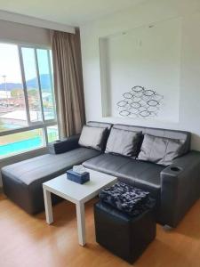 a living room with a black leather couch and a table at 2 Bedroom Apartment only 10 min from Patong beach in Kathu