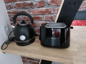 a black tea kettle sitting on top of a counter at Studio Laly in Le Tréport