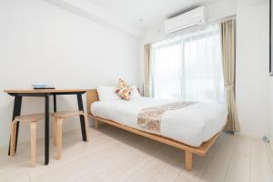 En eller flere senge i et værelse på リアル大久保　Apartment Hotel
