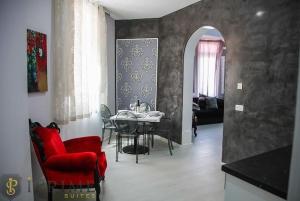 a dining room with a table and a red chair at Sliema Central Iprime Suites in Sliema