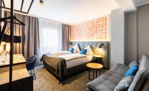um quarto de hotel com uma cama e um sofá em YORS Boutique Hotel em Hanôver