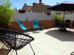 une terrasse avec des chaises, une table et un parasol dans l'établissement Chic et douillet, à Perpignan