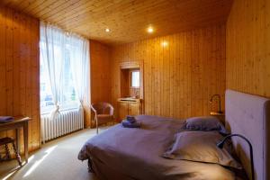 um quarto com uma cama num quarto de madeira com uma janela em Le Huic - Maison pour 9 avec jardin proche plage em Bénodet