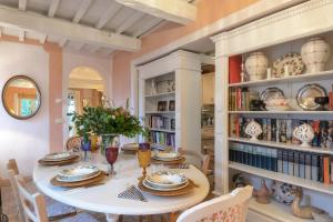 een eetkamer met een tafel en stoelen en een boekenplank bij PODERE SAN GIORGIO 6, Emma Villas in Manciano