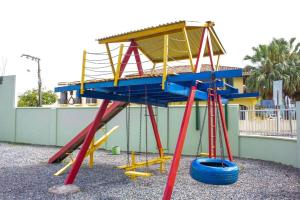 um parque infantil com uma estrutura de brincar azul e amarelo em HN-Hotel Natal Penha em Penha