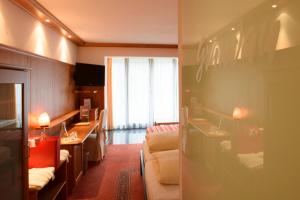 ザンクト・ガレンキルヒにあるBoutiquethotel Grandauのソファとリビングルームが備わるホテルルームです。