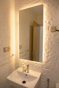 een badkamer met een witte wastafel en een spiegel bij Piso céntrico y a pie de playa. in Martil