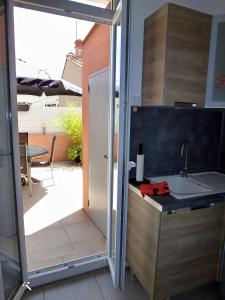 uma cozinha com um lavatório e uma porta de vidro deslizante em Chic et douillet em Perpignan