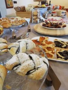 a table topped with different types of pastries and pies at Azienda Agrituristica Le Betulle in Riotorto