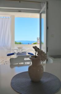 a vase with a flower sitting on top of a table at Apartment Elena in Sumartin