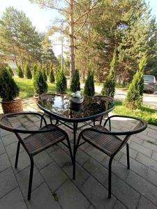 une table de patio avec deux chaises et une fontaine dans l'établissement Apartman Lav, à Divčibare