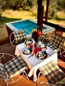 a table with food on it next to a pool at Majuli River House in Marloth Park