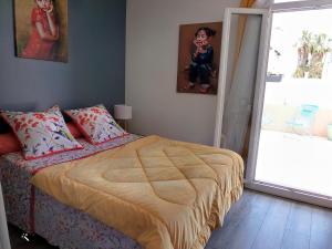 - une chambre avec un lit et un enfant assis sur une fenêtre dans l'établissement Chic et douillet, à Perpignan