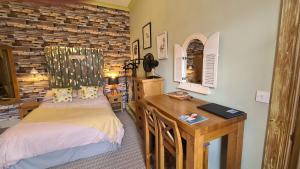 1 dormitorio con 2 camas y escritorio de madera en The Alder Studio @ The Pheasant en Telford
