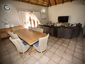 a living room with a wooden table and chairs at Decollage Estate in Polokwane