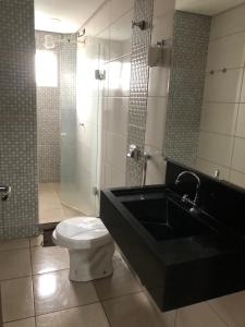 a bathroom with a toilet and a sink and a shower at hotel nacional palace in Foz do Iguaçu