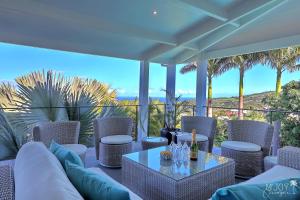 un patio con mesa y sillas con vistas al océano en VILLA MALOYA Piscine Jacuzzi et Vue mer avec Jardin, en Étang-Salé