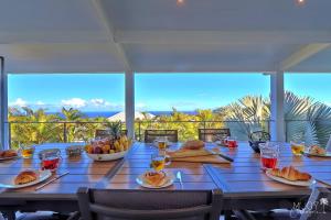 una mesa con comida y vistas al océano en VILLA MALOYA Piscine Jacuzzi et Vue mer avec Jardin, en Étang-Salé