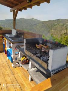 a grill on a deck with a view of mountains at Yurte in Langa in Bosia
