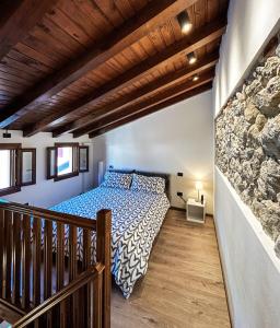 a bedroom with a bed and a stone wall at Il Vicoletto in Marostica
