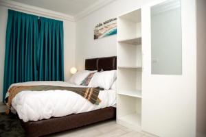 ein Schlafzimmer mit einem Bett und einem blauen Vorhang in der Unterkunft 1995 Apartment in Accra