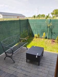 a bench and a table on a patio with a fence at Apartament Nowy Władek 3 in Władysławowo