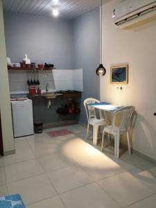 Paraíso do Boldró Flat في فرناندو دي نورونها: مطبخ مع طاولة وكراسي في غرفة
