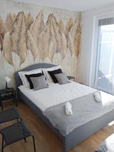 a bedroom with a large bed with a wall with feathers at Apartament Nowy Władek 3 in Władysławowo