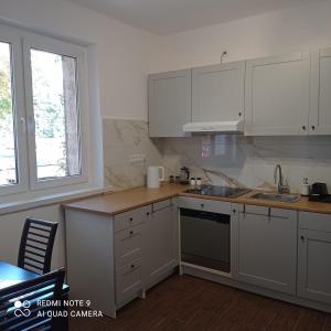 a kitchen with white cabinets and a sink and a window at Hostel Wiśniowa 55 in Wrocław