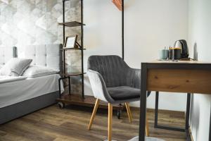 een slaapkamer met een bed, een bureau en een stoel bij Hotel Arko in Praag