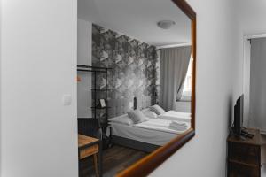 a bedroom with a bed and a mirror at Hotel Arko in Prague