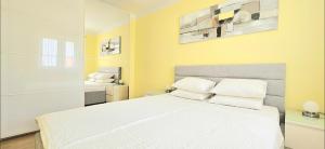 a bedroom with a white bed with white pillows at apartments oaza, vrsi mulo in Vrsi