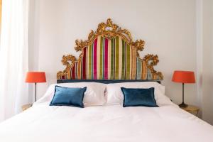 a bedroom with a large white bed with two blue pillows at Diladdarno-Florence style APT in Florence